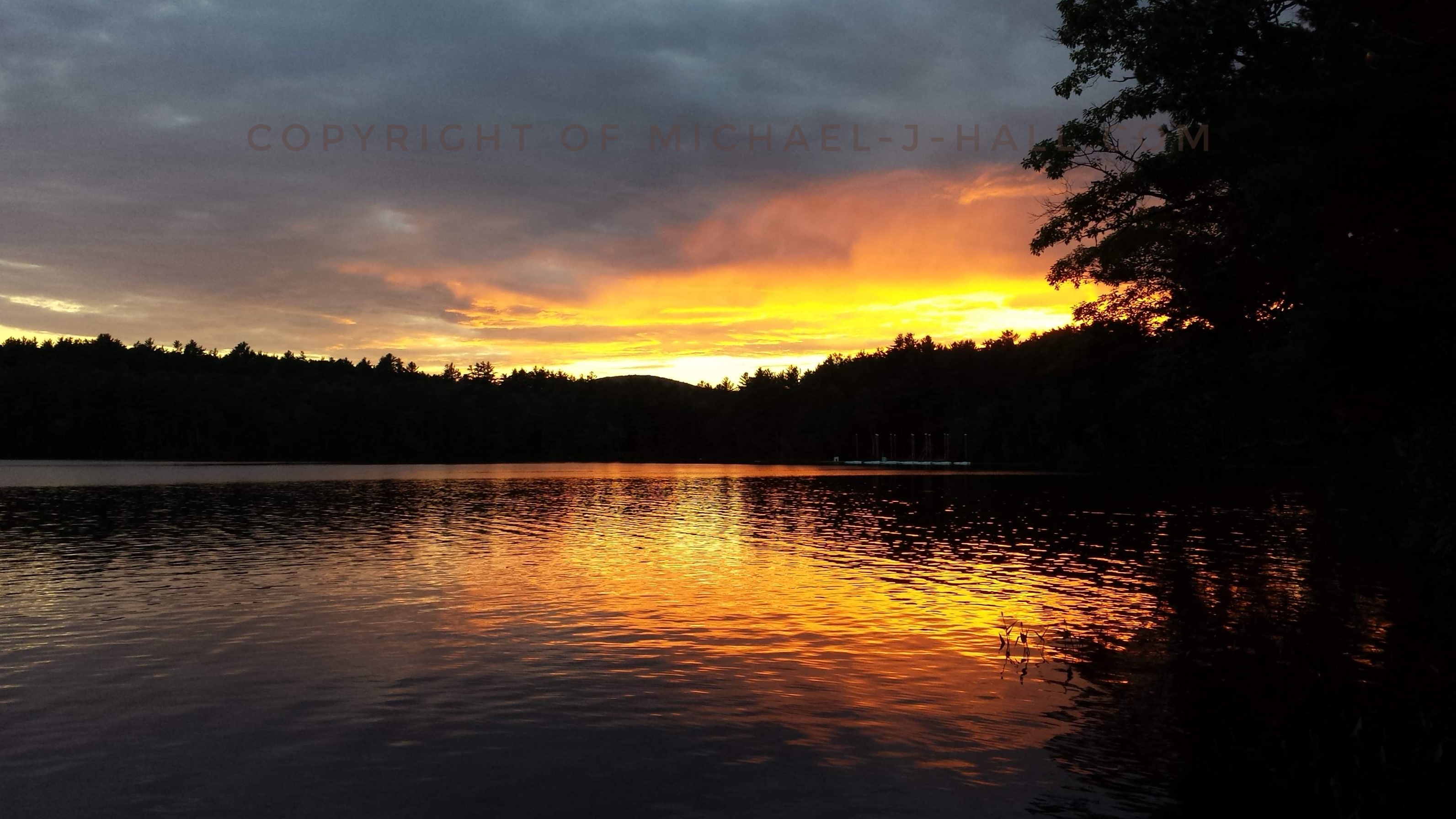 Silhouettes of trees and hills on this midsummer's eve surround Lake Eileen serve as a barrier between the water and sky,  dampening the last embers of the warm day.