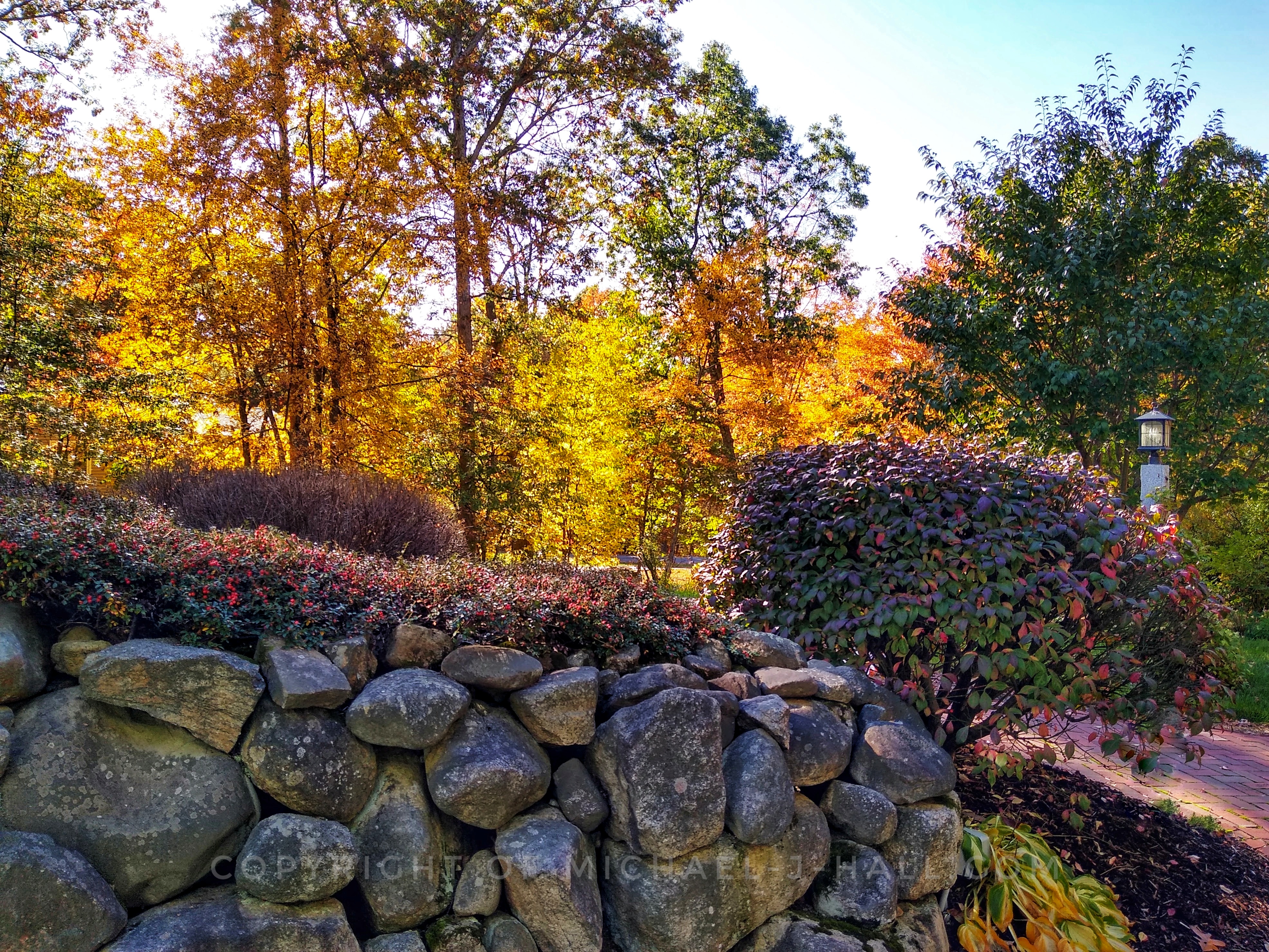 Halloween is around the corner, but nature is the treat here, with fiery hues lighting up the surrounding flora and giving the illusion that a journey up the brick walkway might be perilous.
